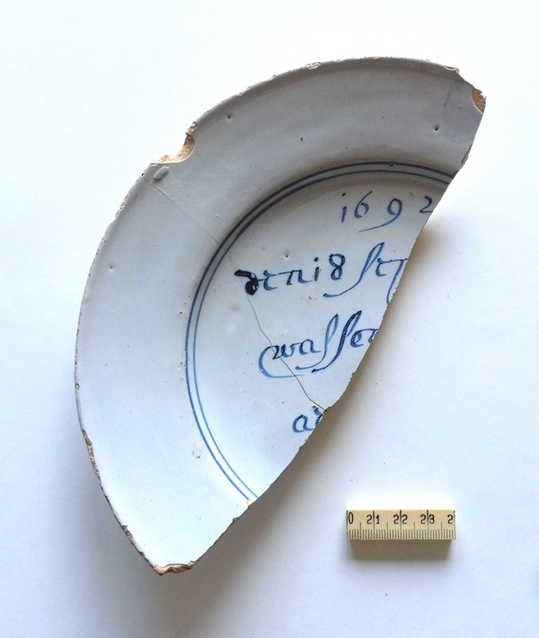M.5. Gedeelte van een in Huissen gevonden bord. Het verwijst naar een aardbeving uit 1692 die ook in Huissen gevoeld moet zijn